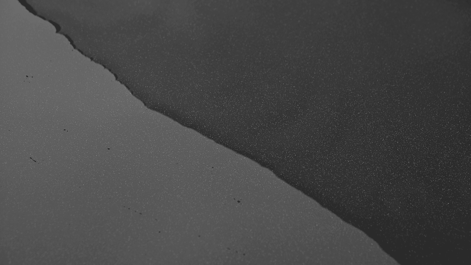 黒い塗装面を流れる水のクローズアップ
